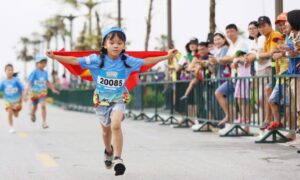 Trẻ em cầm cờ Tổ quốc ăn mừng về đích Kun Marathon Hạ Long