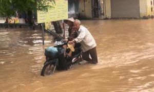 Xúc động cảnh ông lão Hà Nội đẩy xe giữa dòng nước ngập đưa vợ đi khám bệnh